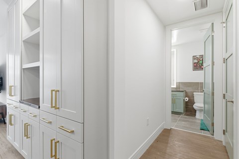 A white kitchen with a white cabinet and a white toilet.