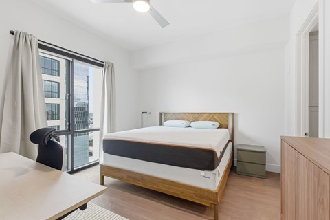 A bedroom with a bed, nightstand, and chair.