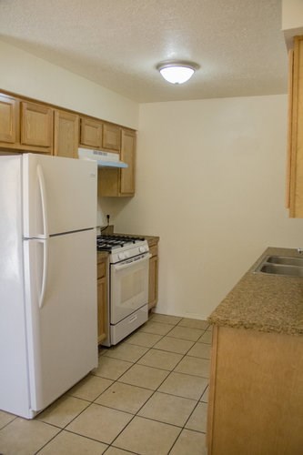 A kitchen with a white refrigerator and a white oven.