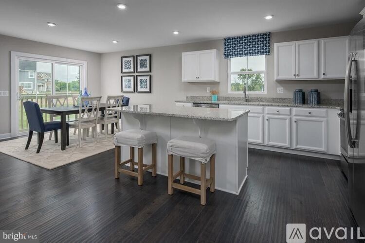 A kitchen with white cabinets and a dining table with chairs.