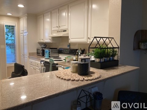 A kitchen with a granite countertop and white cabinets.