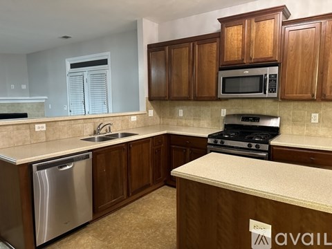 A kitchen with wooden cabinets and a stainless steel dishwasher.