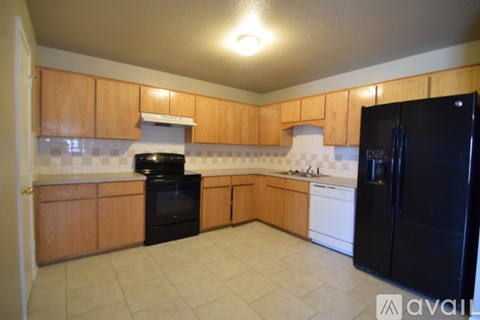 A kitchen with wooden cabinets and black appliances.