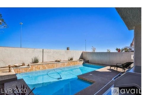 A pool with a blue tiled edge and a black chair.