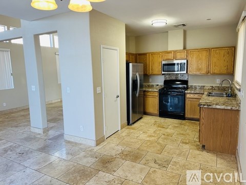 A kitchen with a refrigerator, oven, and microwave.