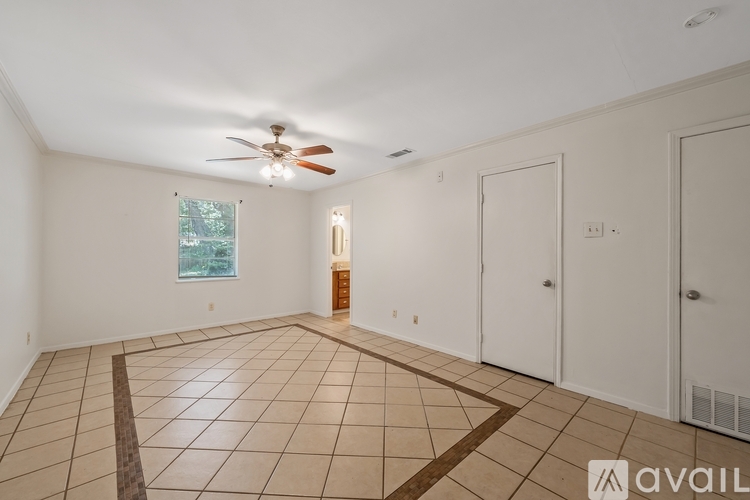A spacious room with a ceiling fan and tiled flooring.