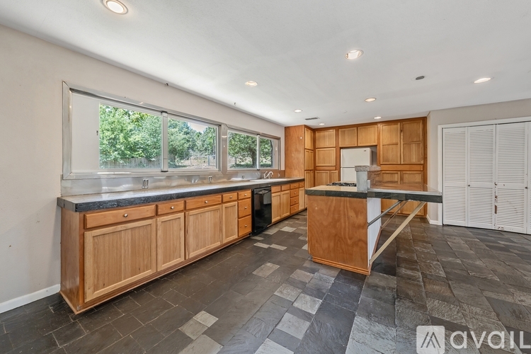 A kitchen with wooden cabinets and black appliances.