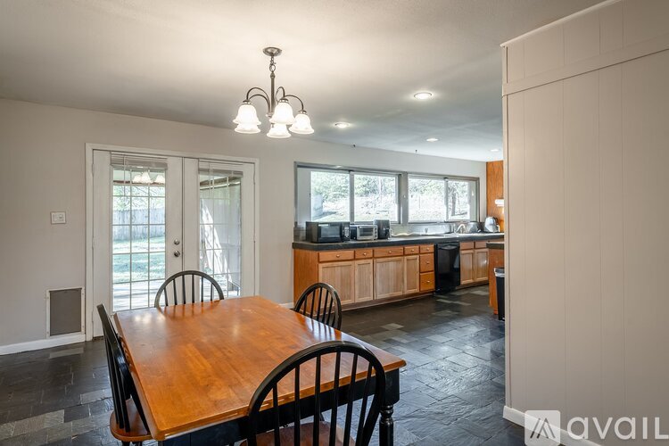 A dining room with a wooden table and chairs.