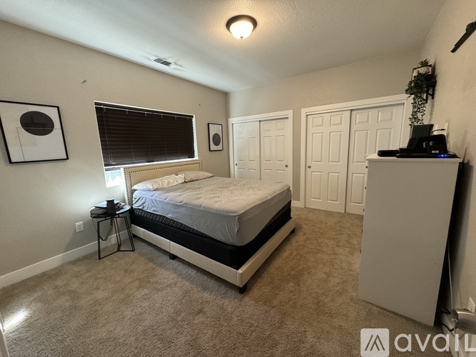 A bedroom with a bed, a nightstand, and a cabinet.