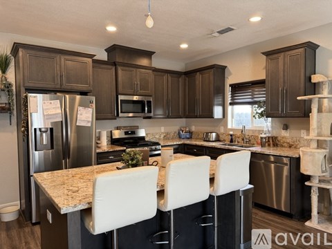A kitchen with dark brown cabinets and a granite countertop.