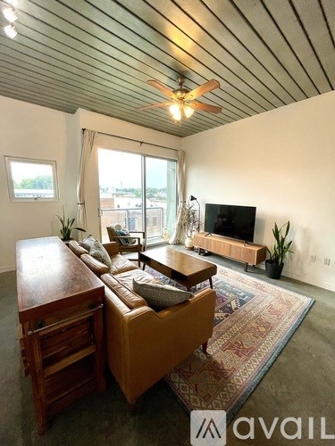 A living room with a brown couch and a wooden table.