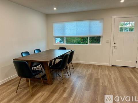 A dining room with a wooden table and chairs.