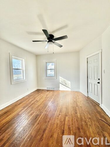 A room with wooden floors and a ceiling fan.