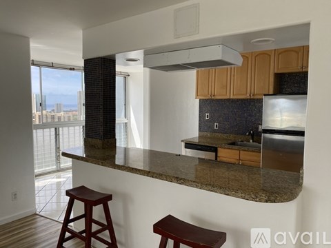 A kitchen with a granite countertop and wooden cabinets.