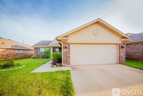 A house with a garage and a driveway in front of it.