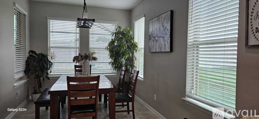 A dining room with a table and chairs.