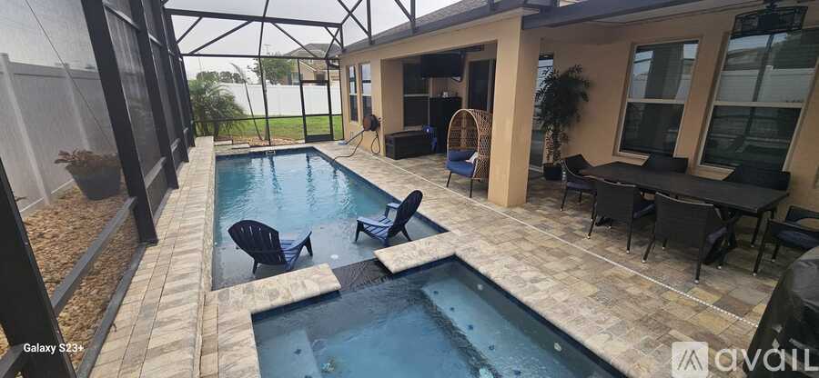 A patio with a pool and chairs.
