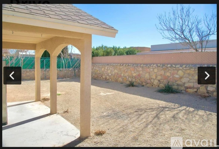 A stone wall with a building in the background.