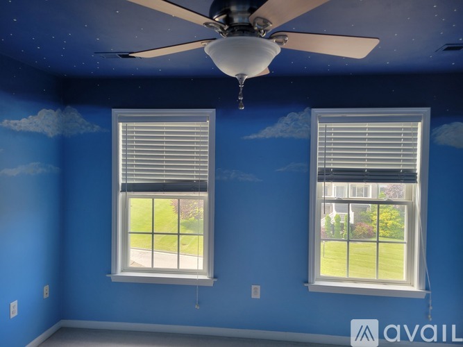 A room with blue walls and a ceiling fan.