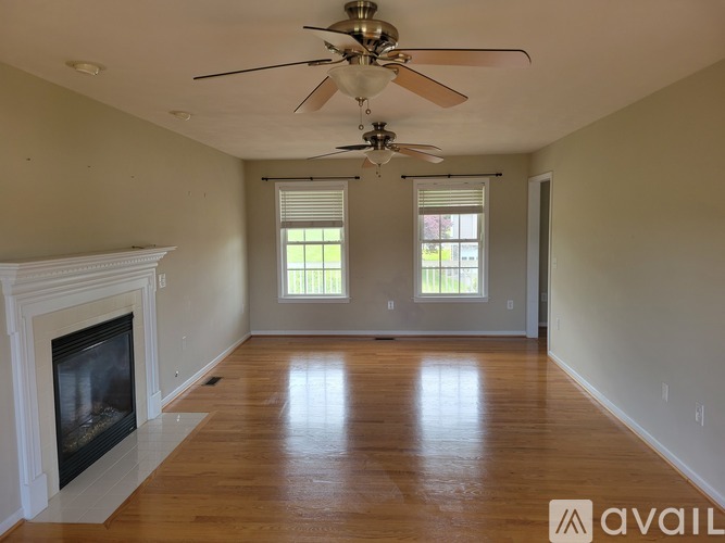 A spacious room with a fireplace and a ceiling fan.