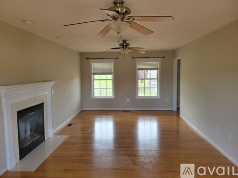 A spacious room with a fireplace and a ceiling fan.
