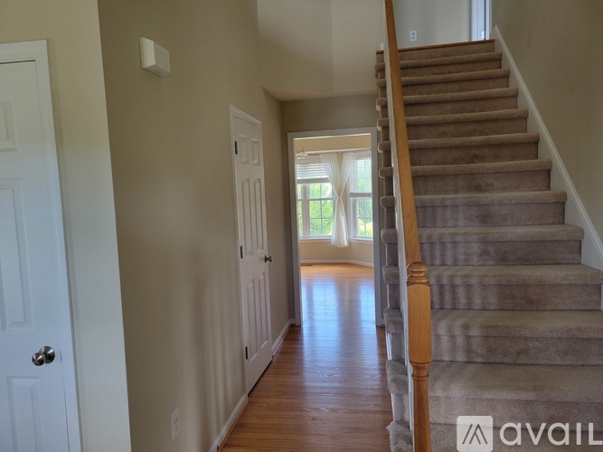 A hallway with a staircase leading to the second floor.