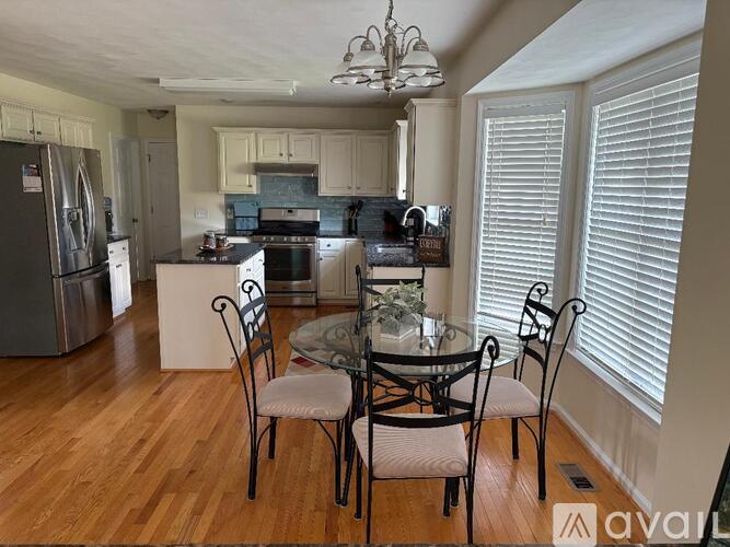 A kitchen with a table and chairs in front of a window.