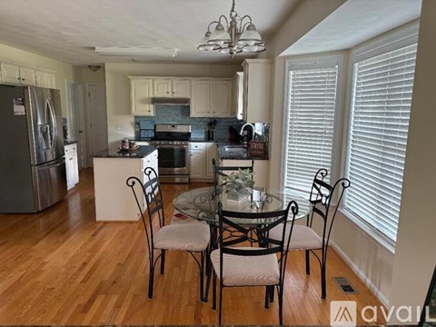 A kitchen with a table and chairs in front of a window.