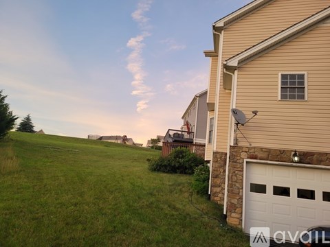 A house with a garage is situated in a grassy area.
