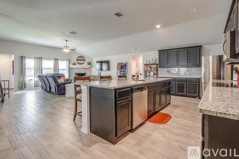 A modern kitchen with dark wood cabinets and a marble countertop.