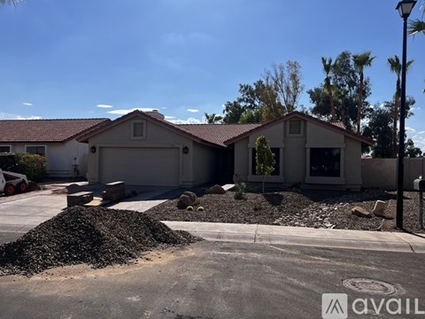 A house with a driveway and a pile of gravel in front.