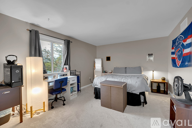 A bedroom with a bed, desk, and chair.