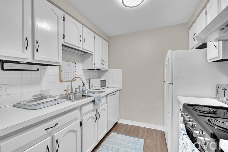 A kitchen with white cabinets and appliances.