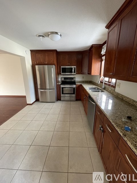 A kitchen with wooden cabinets and a tiled floor.