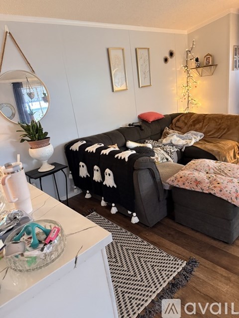 A living room with a black couch and a white table.
