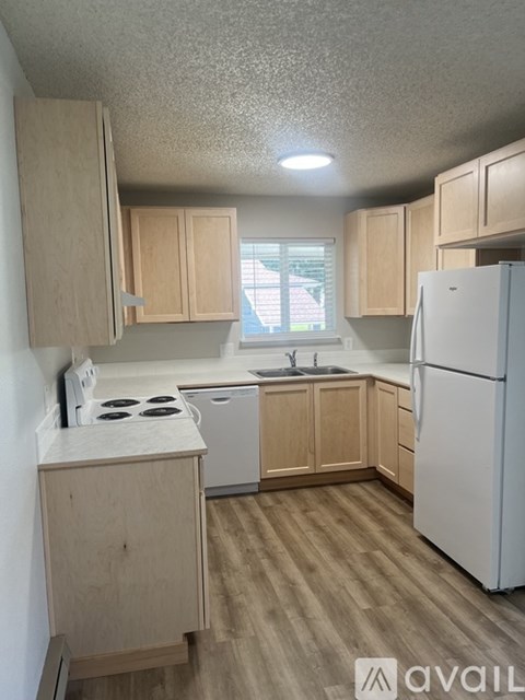 A kitchen with wooden cabinets and a white refrigerator.