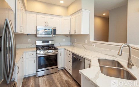 A kitchen with white cabinets and stainless steel appliances.