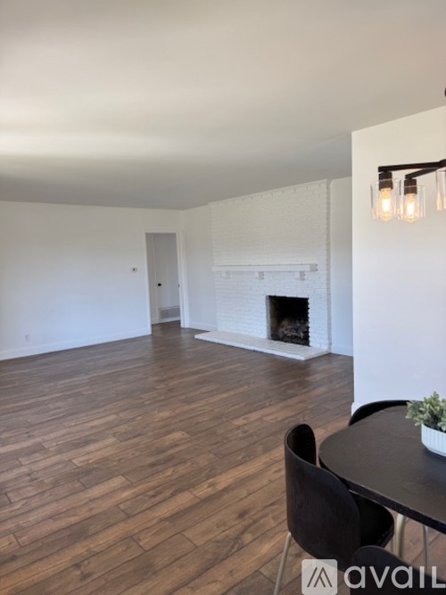 A living room with a fireplace and a dining table.