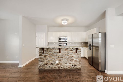 A kitchen with a stone counter top and stainless steel appliances.
