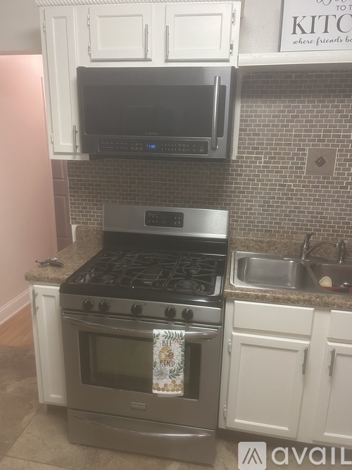 A kitchen with a stove top oven and microwave above it.