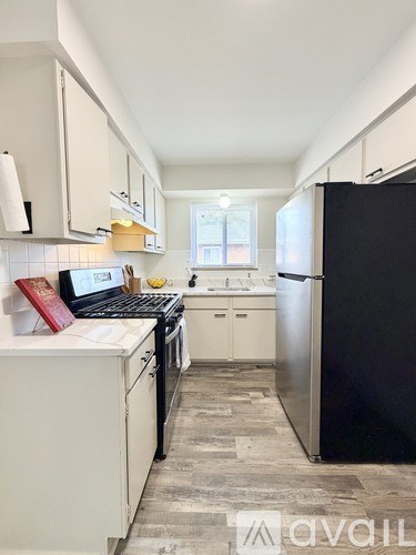 A kitchen with black appliances and white cabinets.