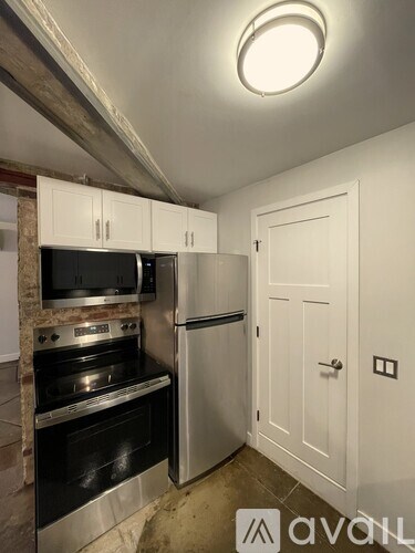 A kitchen with a stove top oven and a refrigerator.