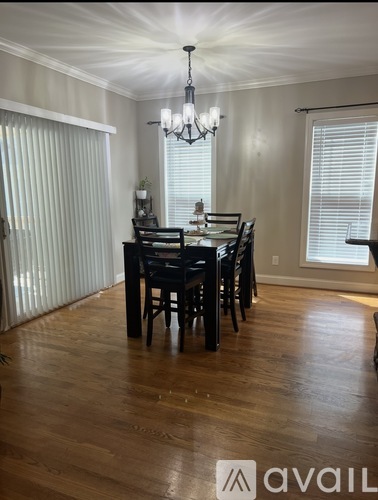 A dining room with a wooden table and chairs.