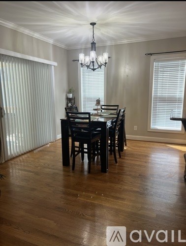 A dining room with a wooden table and chairs.