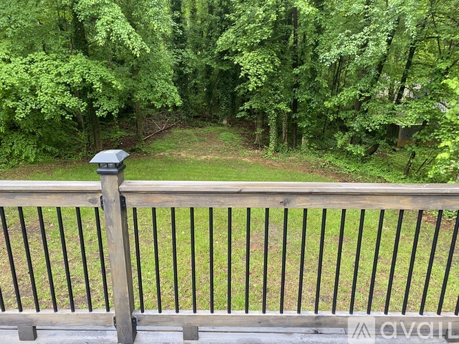 A wooden fence with a mailbox on top overlooks a grassy area.