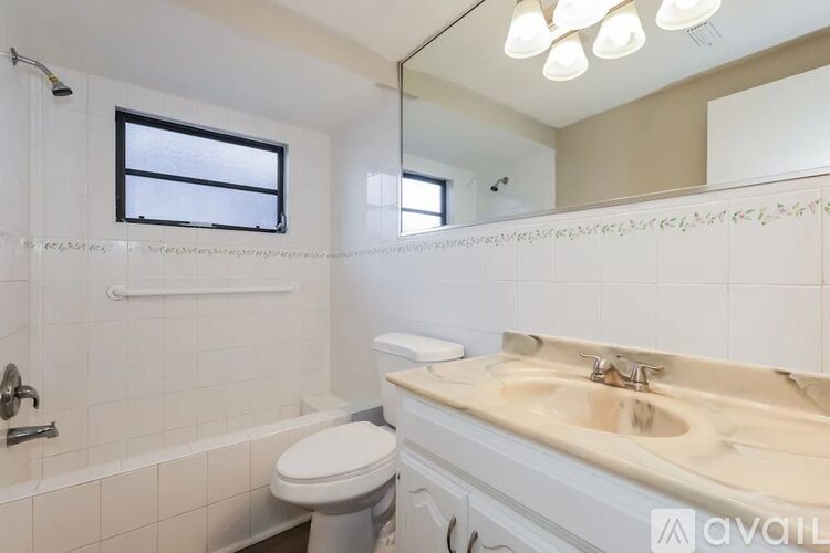 A bathroom with a toilet, sink, and mirror.