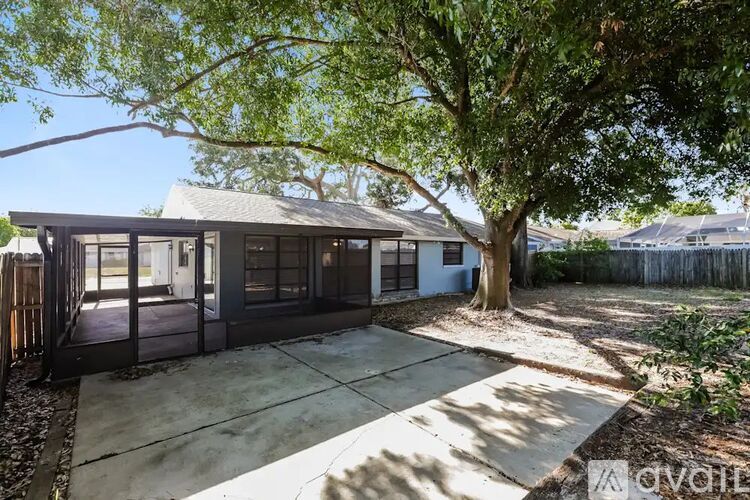 A house with a driveway and a tree in front.