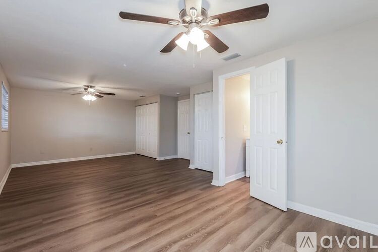 A room with a ceiling fan and wooden flooring.