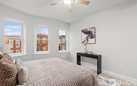 A bedroom with a large bed and a ceiling fan.