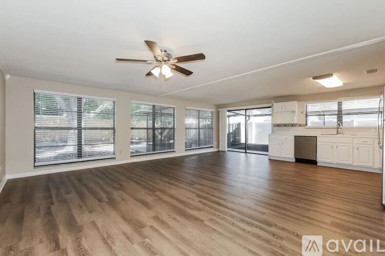 A spacious room with a ceiling fan and wooden flooring.
